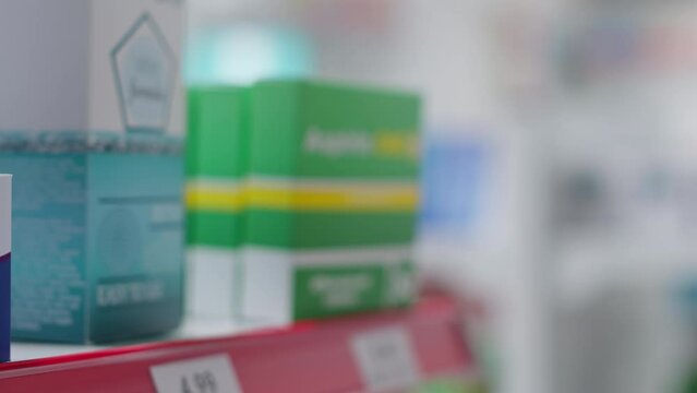 Selective focus of supplements packages on display at medical store, boxes of prescription pills or natural pharmaceutics for sale. Variety of medicaments and nutrients in empty pharmacy.