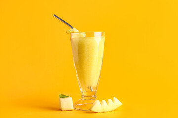 Glass of tasty melon smoothie on orange background