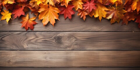 Naklejka na ściany i meble Fall foliage on wooden surface with room for text.