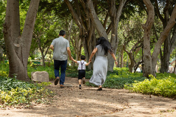 Family members holding hands and walking backwards in a park together family