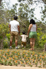Family members holding hands and walking backwards in a park together family