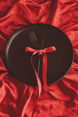 Black plate on a red photo. Holiday concept