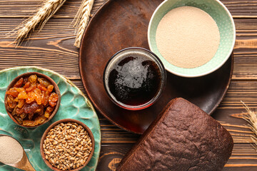 Glass of tasty kvass and ingredients on wooden background