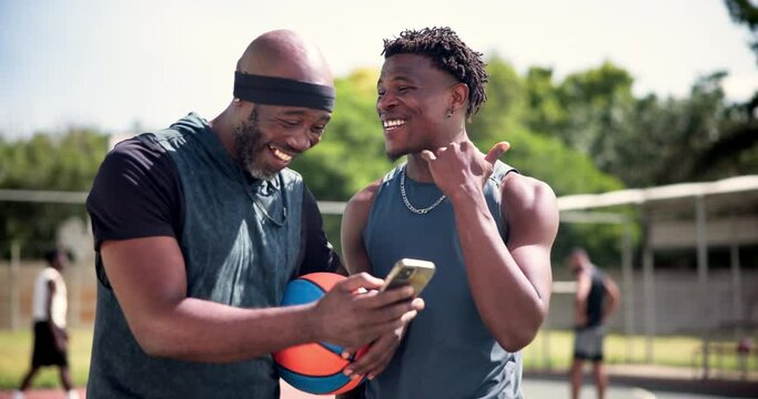 Men, cellphone and basketball on court with athlete, laughing and funny joke with social media meme. African players, happy and smartphone for streaming online and silly sport videos on mobile app