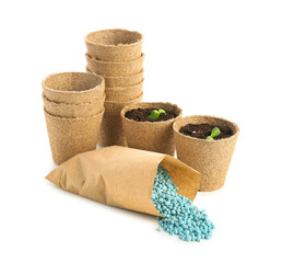 Paper bag with blue granular fertilizer and peat pots isolated on white background
