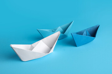 Colorful origami boats on blue background