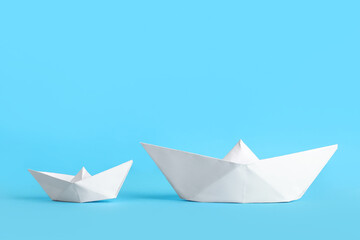 White origami boats on blue background