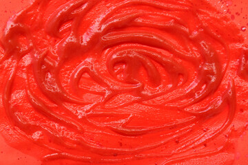 Closeup view of tomato sauce smears on red background