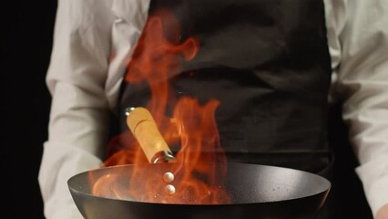 Chef cooking flambe vegetables mix on wok frying pan close-up. Color hot and sweet peppers on fire throwing them on pan. Restaurant Food concept
