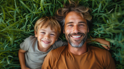 Happy father and son lying in grass together
