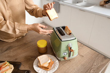 Young beautiful woman making tasty toasts in kitchen, closeup