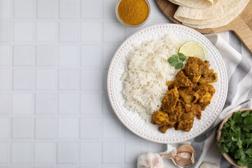 Delicious chicken curry with rice and ingredients on white tiled table, flat lay. Space for text