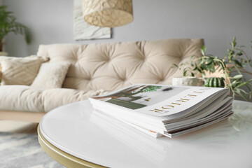 Coffee table with magazines in interior of modern living room, closeup