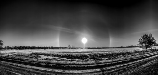 Atmospheric optical phenomenon sun dogs in the morning across a snow field. 