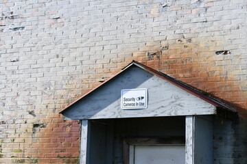 Dingy entrance to military hangar with security camera in use sign.