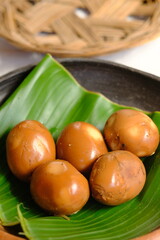 Telur Pindang or Telur Bacem is a boiled egg with sweet soy sauce, brown sugar, and spices. Side dishes for Soto, Pindang Kudus, and Gudeg. Indonesian food. Served in banana leaf on wooden table