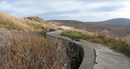 Fort 9 heavy concrete breastwork of Vladivostok fortress overgrown with dry autumn grass