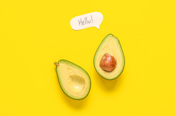 Halves of fresh ripe avocado with speech bubble on yellow background