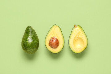 Fresh ripe avocados on green background