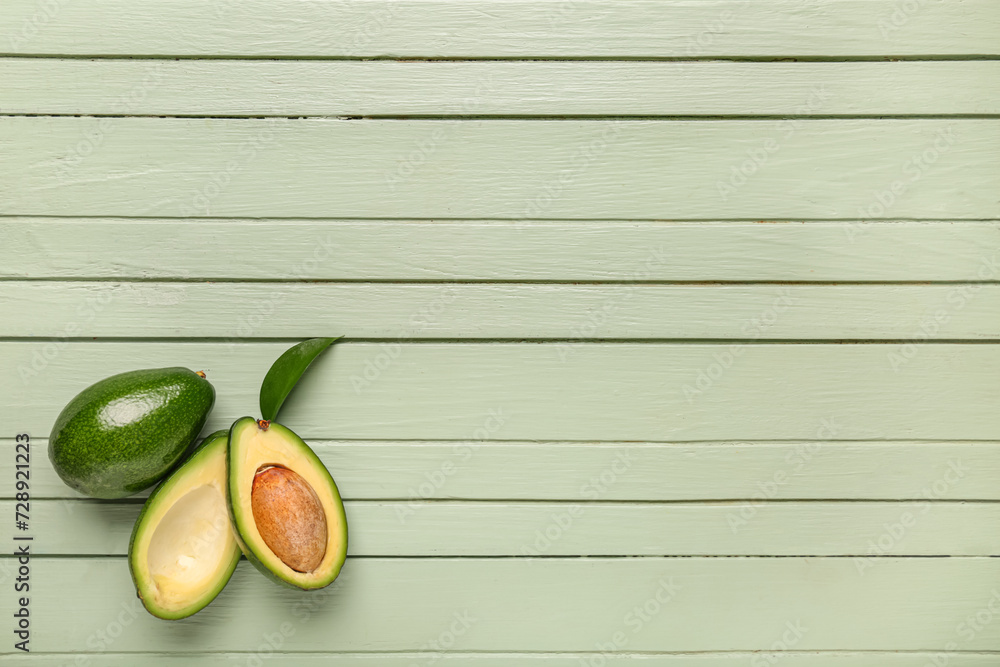 Wall mural fresh ripe avocados and leaf on green wooden background