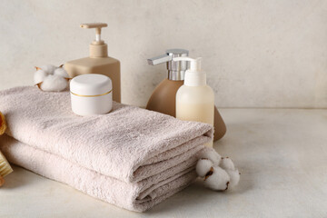 Obraz na płótnie Canvas Set of cosmetic products and clean towels on light background