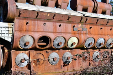 Diesel train engine rusting in field.