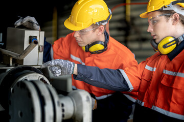 male engineer workers maintenance automatic robotic arm machine in a factory. worker checking and repairing automatic robot hand machine. technician worker check for repair factory machine.