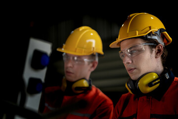 Fototapeta premium male engineer workers maintenance automatic robotic arm machine in a factory. worker checking and repairing automatic robot hand machine. technician worker check for repair factory machine.