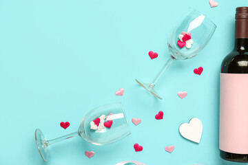 Composition with bottle of wine and glasses for Valentine's day on blue background
