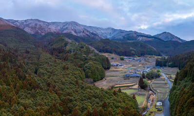 Aerial view of traditional farming village by snow covered mountains of Japan - 728926886