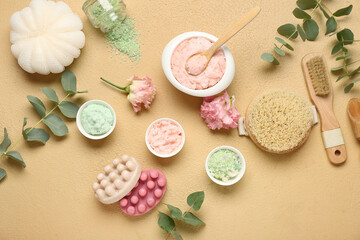 Beautiful spa composition with different body scrubs and eucalyptus branches on color background