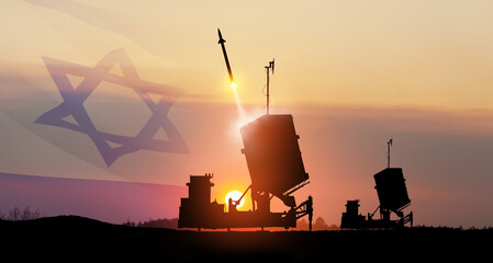 Israel's Iron Dome air defense missile launches. The missiles are aimed at the sky at sunset with...