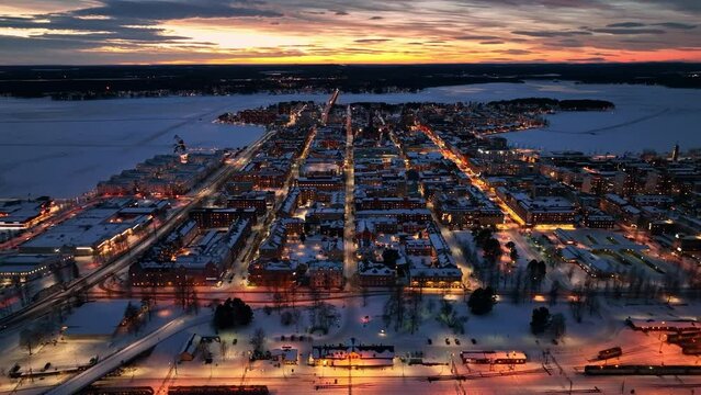 Luleå city at dusk with street lights and snow-covered landscape, aerial, aerial view