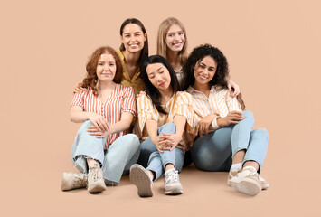 Beautiful young women sitting on beige background. Women history month