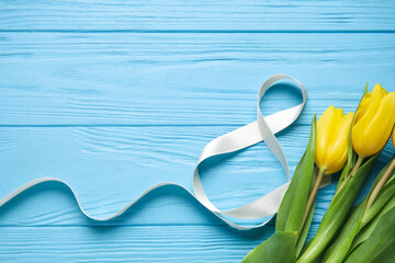 Composition with figure 8 made of ribbon and flowers on blue wooden background. International Women's Day celebration