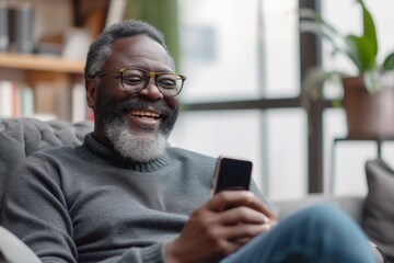 Cheerful african american man in eyeglasses using smartphone
