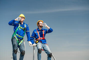 Male technician holding solar panels on factory roof An engineer in a helmet takes a drink break before installing an outdoor solar panel system. solar cell storage