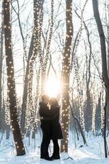 Couple in love hugging and kissing in the winter forest with garland lights.