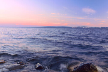Landscape of the water surface of the lake and the sunset evening sky.