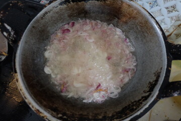 Fried onions are being fried in a frying pan