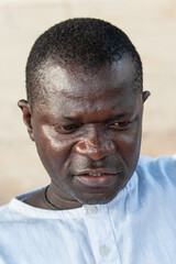 street photography, african man head and shoulders portrait, wearing traditional african shirt
