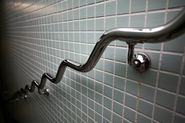 Wobbly chrome handrail on tiled subway wall.Metal Chrome Steel Handrail Public Staircase...