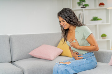 Woman complaining about menstruation abdomen pain in the sofa