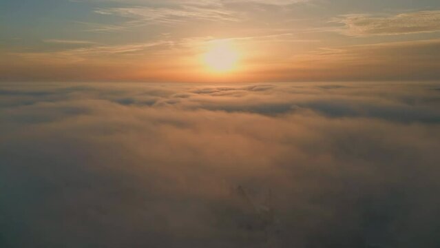 Beautiful sunset cloudy sky aerial view. Golden sun shining over fluffy clouds