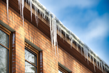 Large icicles hanging from the edge of a roof