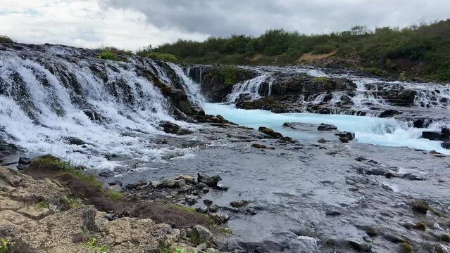 Bruarfoss cascading blue waterfall flowing down Icelandic glacier rocky stream