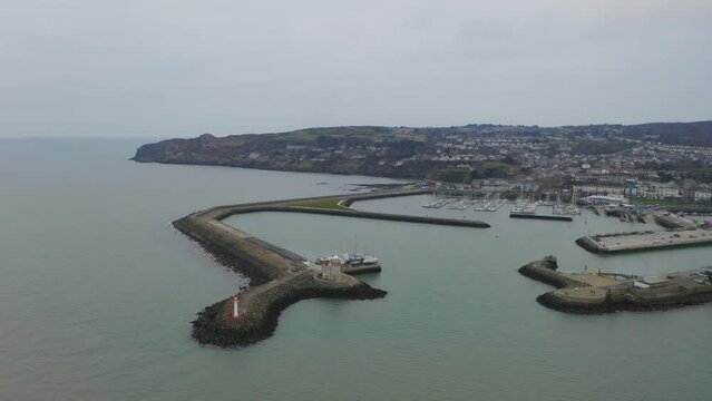 Cinematic aerial orbit of Howth harbour, focusing on the lighthouse
