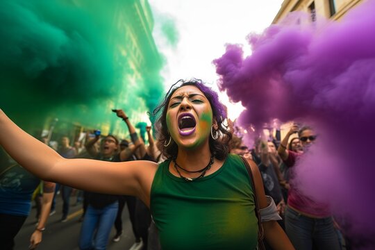hispanic woman with green clothes shouting through megaphone on feminist protest in a crowd in a big city, purple smoke arround
