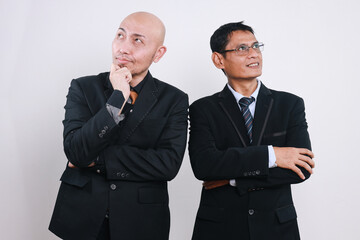 Two corporate business colleagues with arms crossed looking away on white background