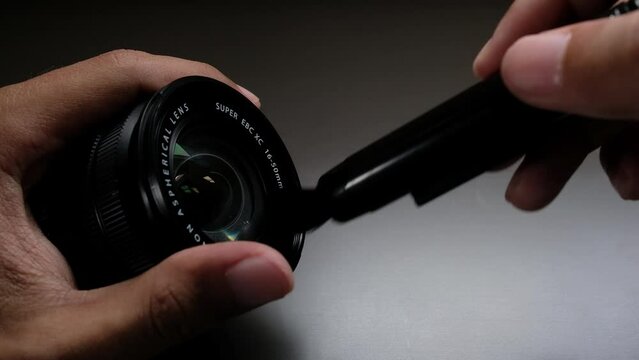 Cleaning a camera lens with a brush tool